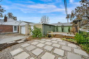 Back of property featuring a patio area, an outbuilding, and a deck