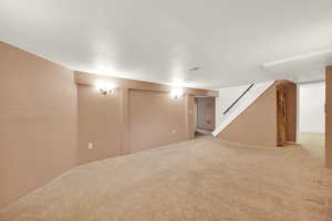 Basement featuring light carpet