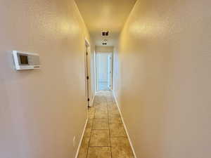 Hallway featuring light tile patterned floors