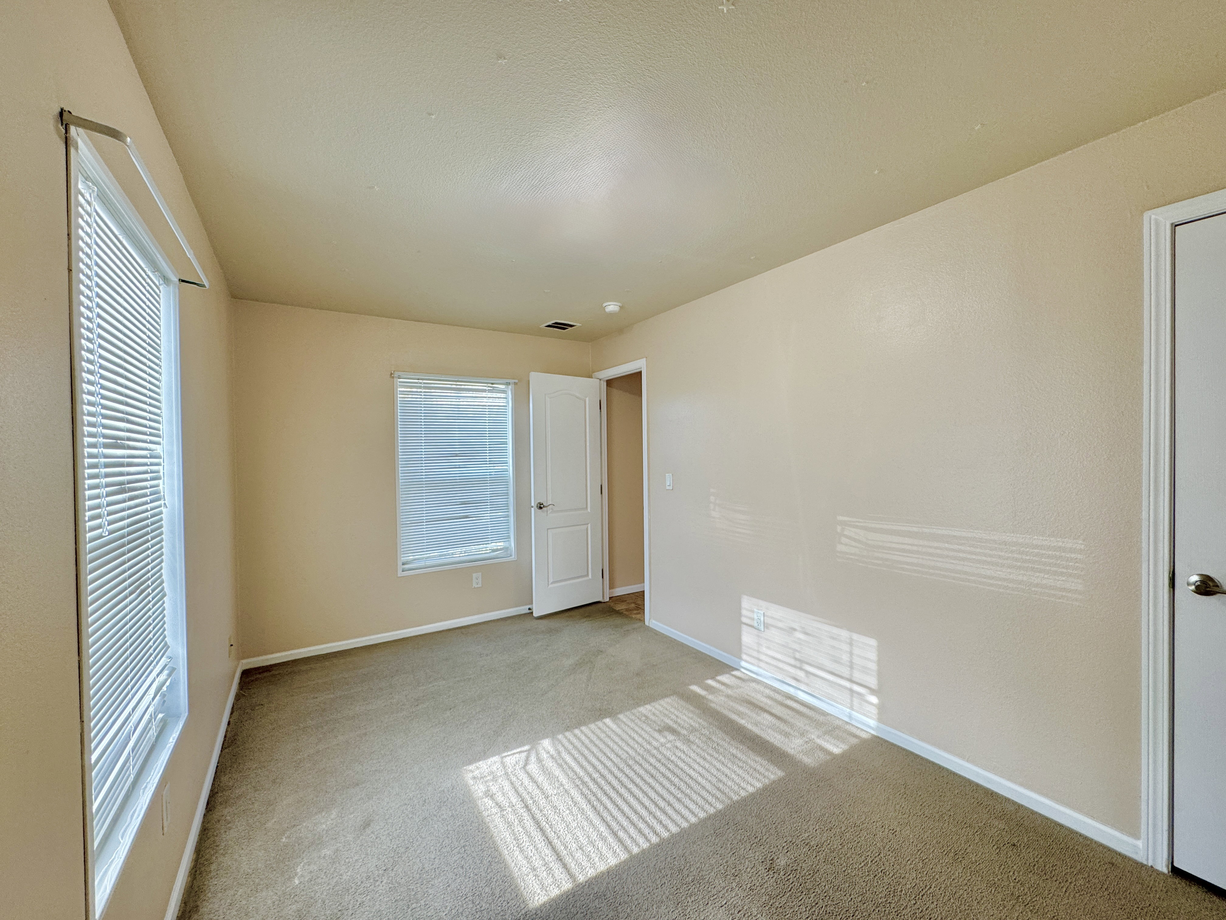 Unfurnished bedroom featuring light colored carpet