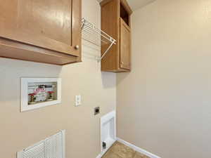 Laundry room featuring cabinets, washer hookup, electric dryer hookup, and light tile patterned flooring