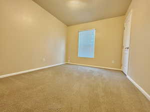 Spare room with carpet and lofted ceiling