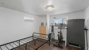 Exercise area featuring a textured ceiling and dark hardwood / wood-style floors