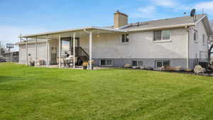 Back of house featuring a yard and central AC unit