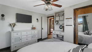 Bedroom with ceiling fan and dark wood-type flooring