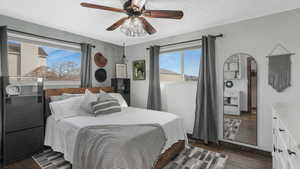 Bedroom with ceiling fan, dark hardwood / wood-style flooring, and a textured ceiling