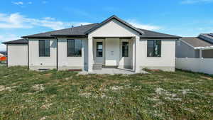 Rear view of property featuring a patio area and a yard