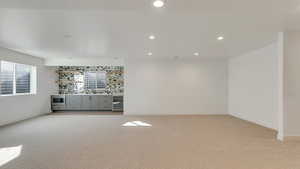 Empty room featuring sink, light colored carpet, and beverage cooler