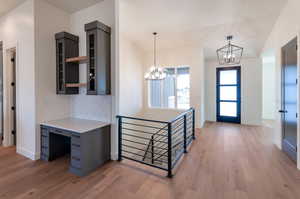 Foyer entrance with light hardwood / wood-style floors and a chandelier