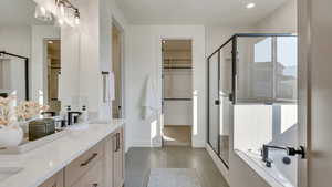 Bathroom featuring tile patterned floors, vanity, and plus walk in shower