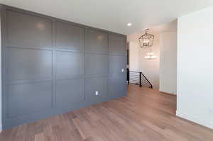 Spare room featuring a chandelier and light hardwood / wood-style floors