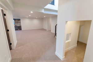 Basement featuring light carpet