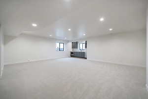 Unfurnished living room with light colored carpet and sink