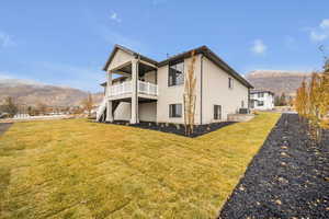 View of property exterior with a mountain view and a yard