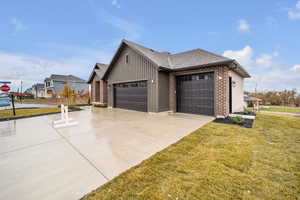 View of home's exterior with a lawn and a garage