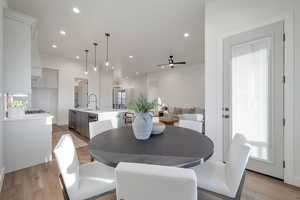 Dining room with ceiling fan, light wood-type flooring, and sink