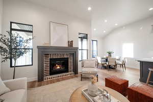 Living room featuring light hardwood / wood-style floors, a fireplace, and a wealth of natural light