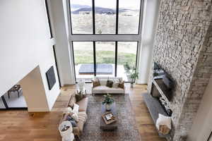 Living room with a mountain view, light wood-type flooring, and a towering ceiling