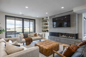 Living room featuring a fireplace, wood-type flooring, and built in shelves