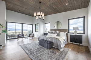 Bedroom featuring multiple windows, wooden ceiling, and a notable chandelier