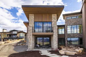 Rear view of house with a patio area, a balcony, and central air condition unit