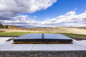 View of patio / terrace featuring a mountain view and a covered hot tub