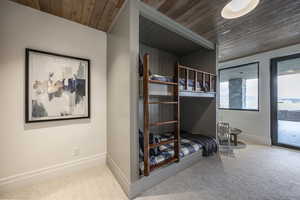 Bedroom with access to exterior, carpet, and wood ceiling