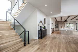 Stairs featuring hardwood / wood-style floors and beam ceiling