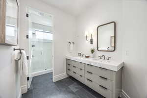 Bathroom with tile patterned flooring, vanity, and a shower with shower door