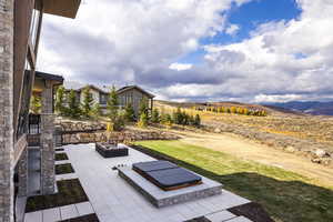 View of yard featuring a mountain view, an outdoor fire pit, and a patio