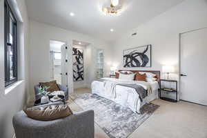 Carpeted bedroom with ensuite bathroom and lofted ceiling