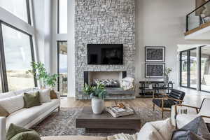 Living room featuring wood-type flooring, a wealth of natural light, and a towering ceiling