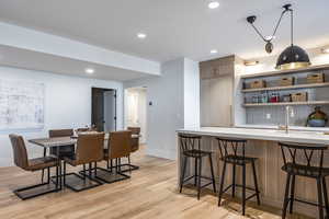 Dining area with light hardwood / wood-style flooring and sink