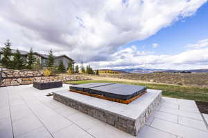 View of patio / terrace featuring a mountain view and a covered hot tub