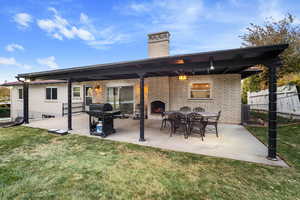 Rear view of house with a lawn and a patio area