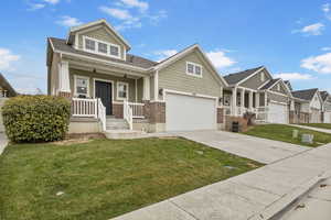 Craftsman inspired home featuring a garage, a porch, and a front yard