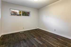 Main floor bedroom featuring dark wood-type flooring