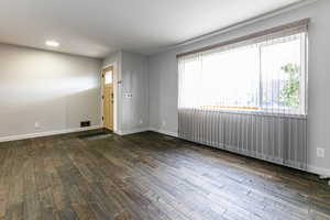 Living room with dark hardwood / wood-style flooring and a wealth of natural light