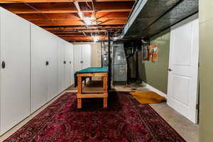 Basement storage room featuring heating unit and gas water heater