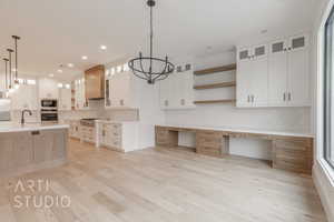 Kitchen featuring white cabinets, appliances with stainless steel finishes, light wood-type flooring, and a healthy amount of sunlight