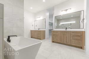 Bathroom featuring separate shower and tub, vanity, and tile walls