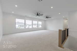 Empty room with plenty of natural light, ceiling fan, and light carpet