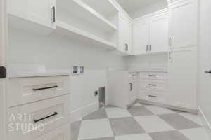 Washroom featuring electric dryer hookup, cabinets, and washer hookup