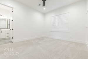 Empty room with ceiling fan and light carpet