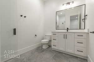 Bathroom with toilet, tile patterned flooring, vanity, and walk in shower