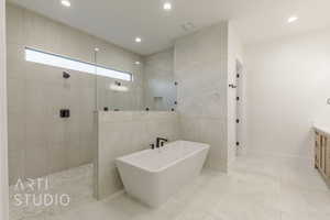 Bathroom featuring vanity, separate shower and tub, and tile walls