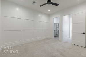 Interior space featuring a walk in closet, ceiling fan, a closet, and light carpet