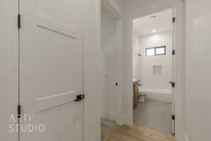 Full bathroom with hardwood / wood-style floors, vanity, toilet, and tiled shower / bath