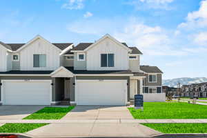 View of front facade featuring a mountain view, a front lawn, and a garage