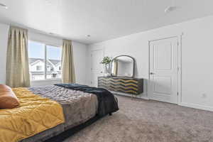 Bedroom featuring carpet floors and a textured ceiling